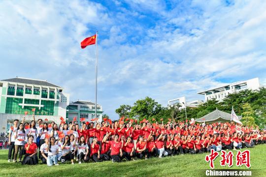 9月2日，beat365中文官方网站，学生们在入学升国旗仪式结束后与国旗合影。　陈骥旻 摄